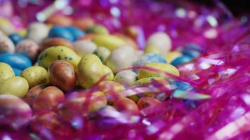 rotierender Schuss von bunten Ostersüßigkeiten auf einem Bett des Ostergrases - Ostern 143 video