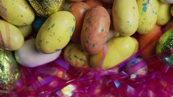 Tourné de bonbons de Pâques colorés sur un lit d'herbe de Pâques - Pâques 169 video