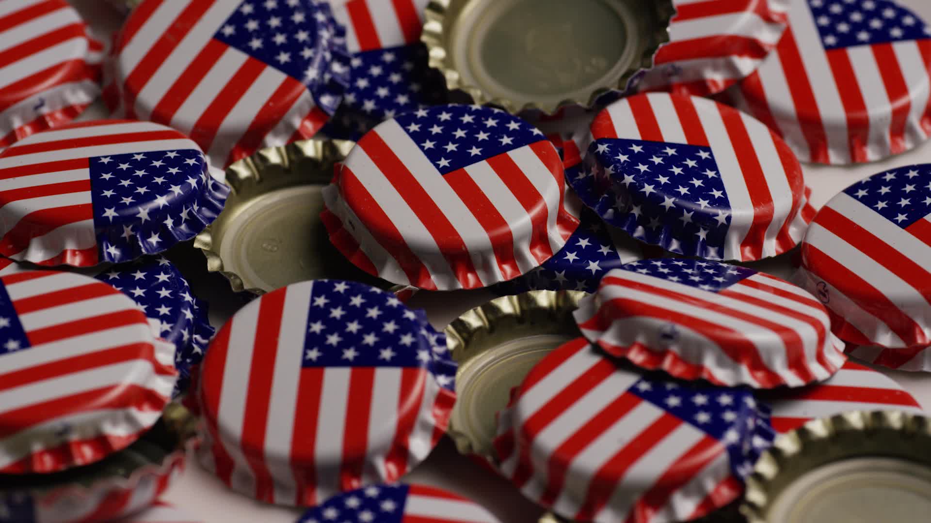 Rotating shot of bottle caps with the American flag printed on them