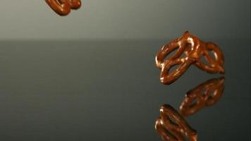 pretzels cayendo y rebotando en cámara ultra lenta (1,500 fps) sobre una superficie reflectante - pretzels phantom 029 video