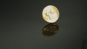 goldene Münze, die sich in Ultra-Zeitlupe (1.500 fps) auf einer reflektierenden Oberfläche dreht - Geldmünzen-Phantom 003 video