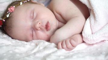 Neugeborenes kleines Mädchen schläft auf dem Bett, süße Träume von kleinem Baby, gesunder Schlaf.