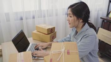 mujer de negocios propietaria de pyme online comprobando el producto en stock y guardando en la computadora que viene en casa. video