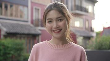 glad vacker ung asiatisk kvinna som känner sig lycklig och ler mot kameran när hon reser i chinatown i Beijing, Kina. video