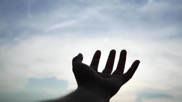 la mano del hombre alcanza el sol. video