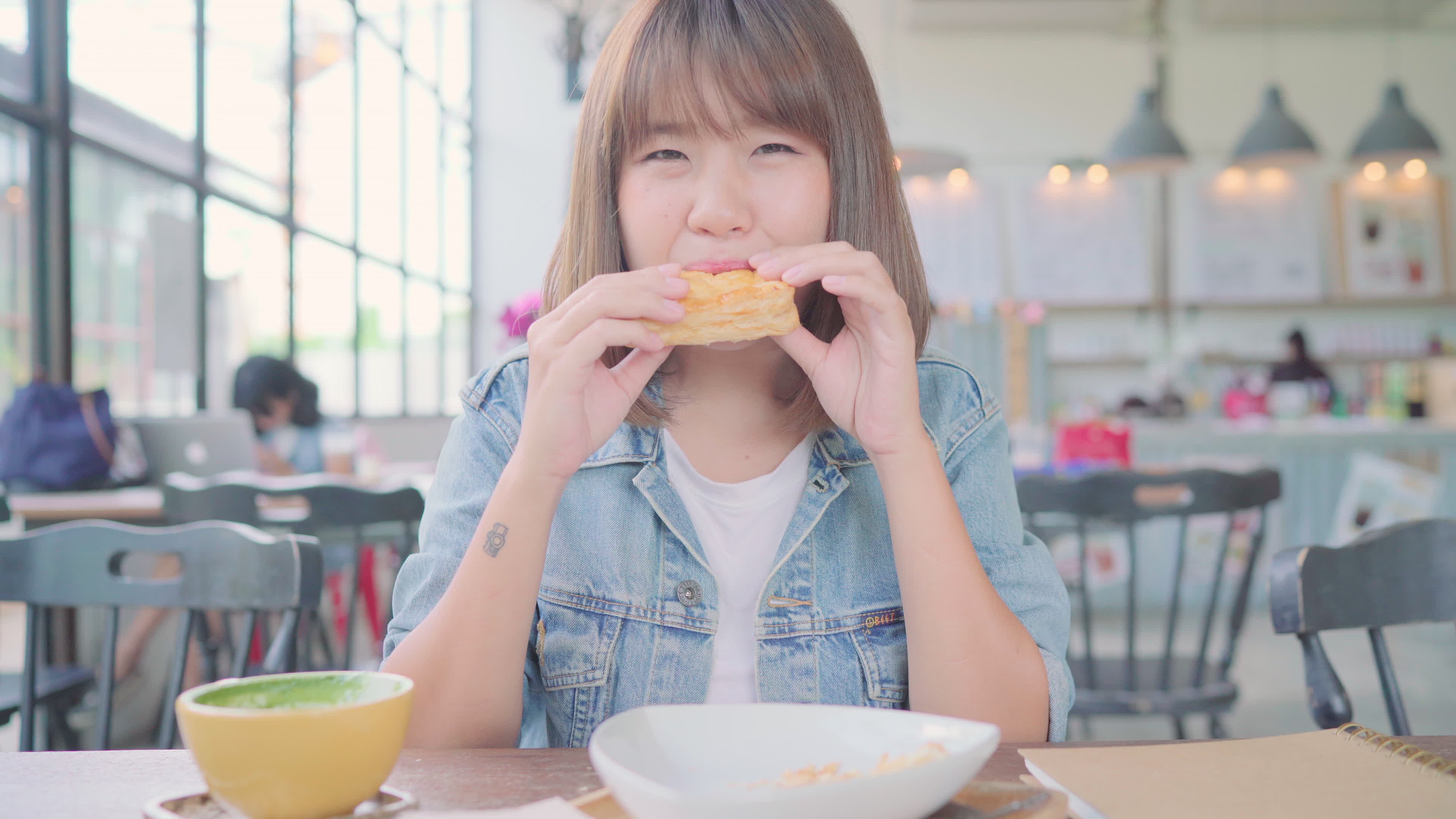 Realistic reading asian woman sitting on a swing with warm cup of tea on modern table near her. студенты завтракают в столовой. подруги в ресторане. для повышения аппетита. кушать в кафе.