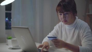 vacker asiatisk kvinna som köper online med kreditkort. video
