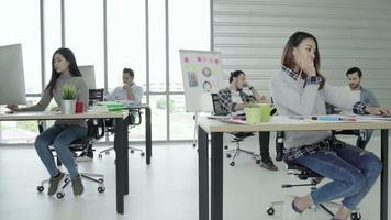 Homens e mulheres de negócios criativos asiáticos desfrutam e se divertem dançando ao entrar em seu escritório.
