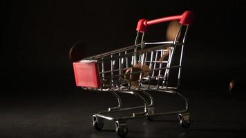 Euro Coins falling down on a mini shopping cart video