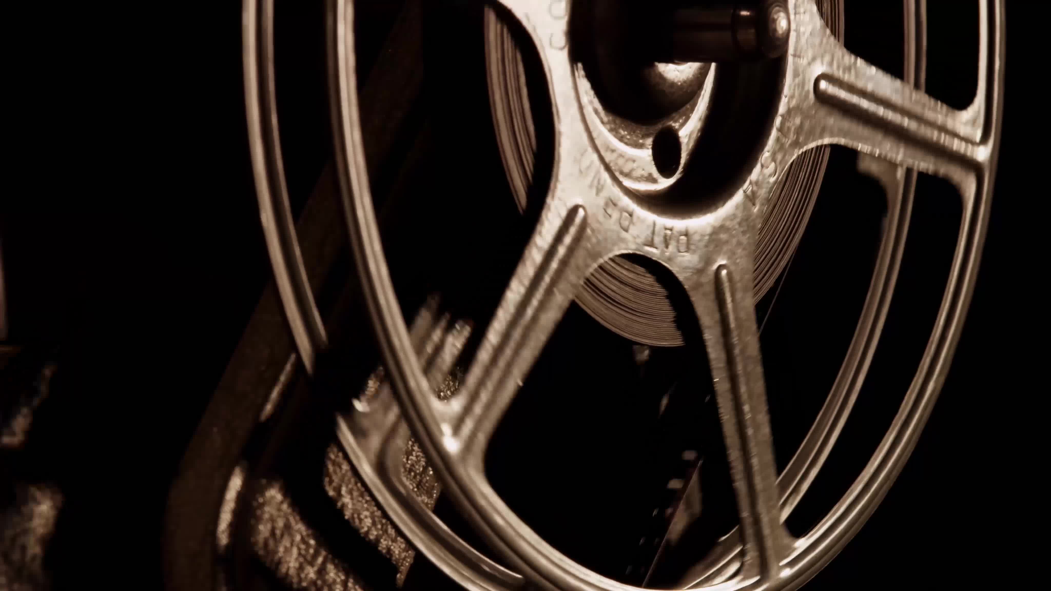 Close up of 8mm movie projector, showing half film reel spinning and