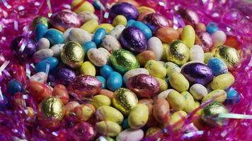 Tournage de bonbons de Pâques colorés sur un lit d'herbe de Pâques - Pâques 172