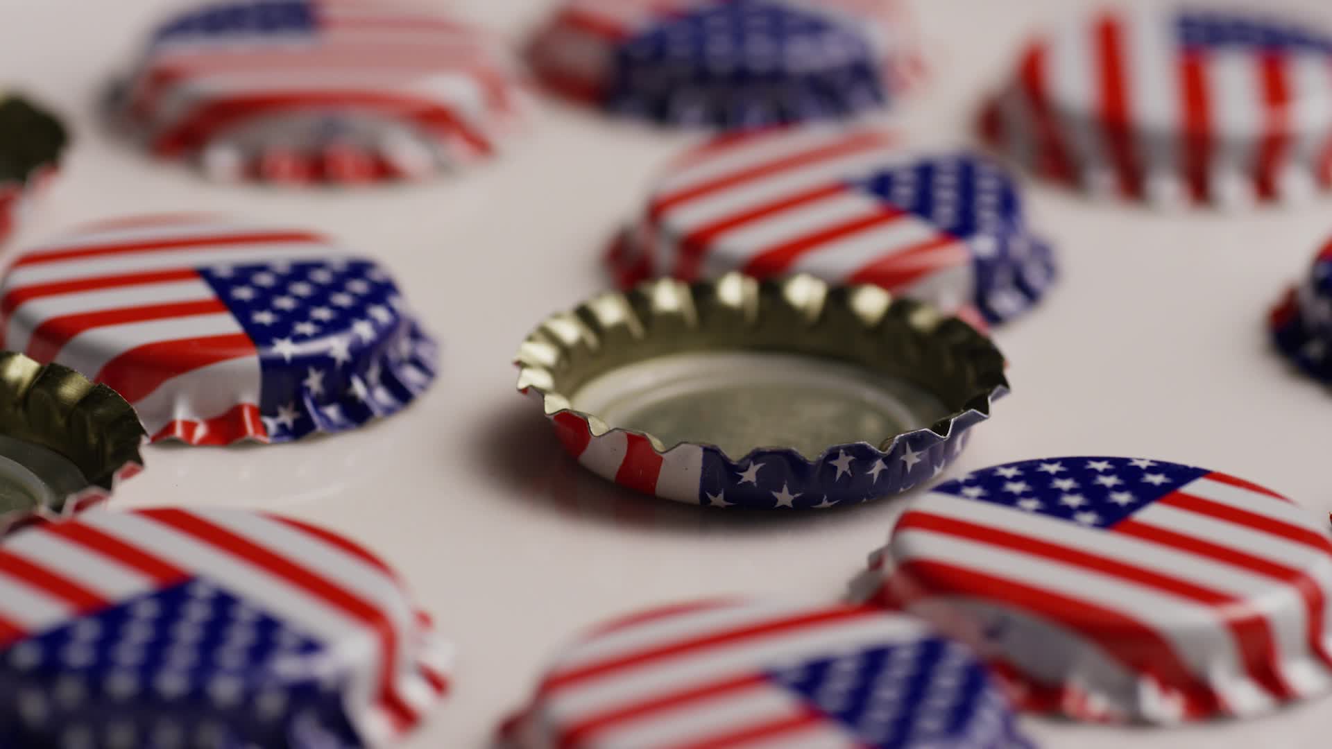 Rotating shot of bottle caps with the American flag printed on them