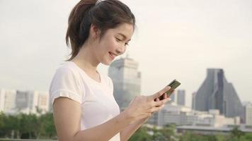 joyeuse femme de blogueur touristique asiatique à l'aide de smartphone pour la direction et à la recherche sur la carte de localisation. video