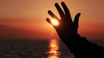 Silhouette der Hand bei Sonnenuntergang Sonne video
