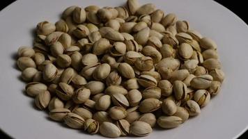 Cinematic, rotating shot of pistachios on a white surface - PISTACHIOS 034 video