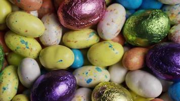 Tourné en rotation de bonbons de Pâques colorés sur un lit d'herbe de Pâques - Pâques 164 video