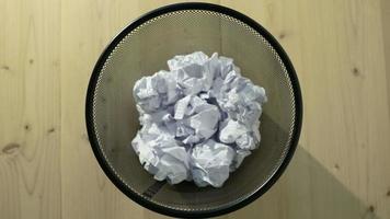 White crumpled paper being thrown into a trash bin video