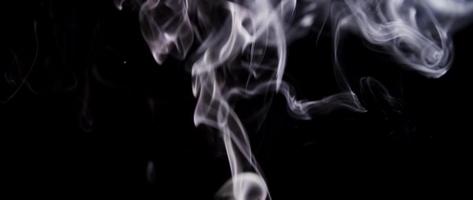 White smoke spirals spinning and creating waves going up in dark barkground in 4K video