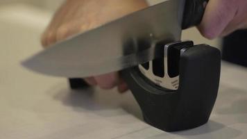 Man's Hand Sharpens a Knife on the Sharpener video