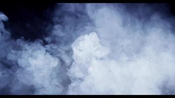 gecontroleerde rook creëert zware wolken van links naar rechts op een donkere achtergrond in 4k video