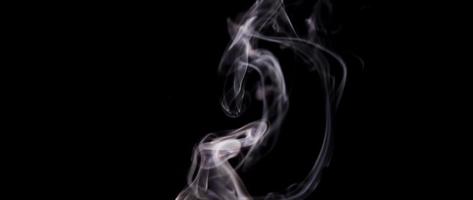 Hypnotic white smoke floating and going up drawing spirals and swirls in 4K
