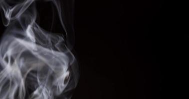 Extreme close up of white smoke creating swirls and spirals in focused and blurred focal points in 4K video