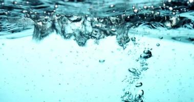 Blue scene of water container showing in upper section the water surface with waves in 4K video