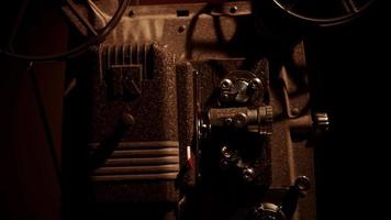 vista lateral de um close-up de um projetor de filmes de 8 mm com rolos de filme girando 4k video