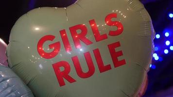 niñas gobiernan globo flotando en una fiesta con luces detrás | material de archivo gratis
