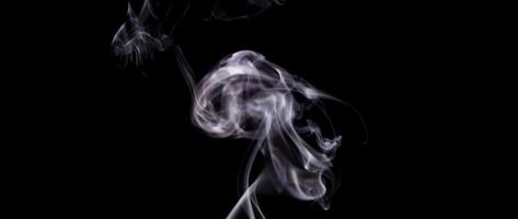 Blurred and focused focal points of soft white smoke floating in darkness in 4K video