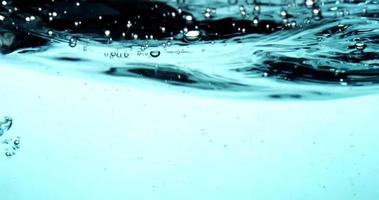 scène de vagues et de bulles flottant dans un liquide bleu en 4k