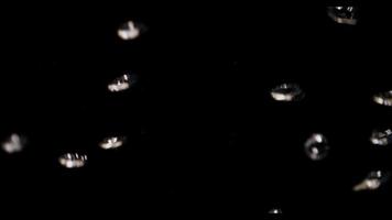 Close up of shiny bubbles floating fast in dark aquarium in 4K video