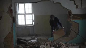 Depressed and mad man throws board on the floor in an abandoned house video