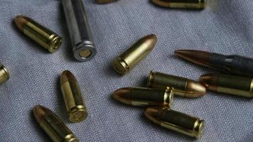 Cinematic rotating shot of bullets on a fabric surface - BULLETS 089 video