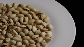 Cinematic, rotating shot of pistachios on a white surface - PISTACHIOS 012 video