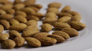 Plan cinématique et rotatif d'amandes sur une surface blanche - amandes 013 video