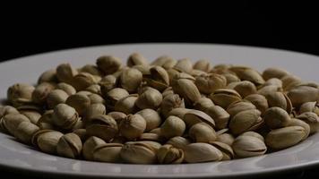 Cinematic, rotating shot of pistachios on a white surface - PISTACHIOS 039 video