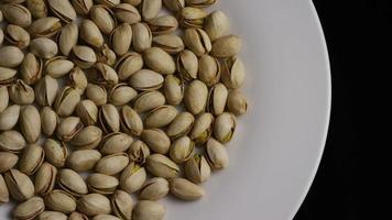 Cinematic, rotating shot of pistachios on a white surface - PISTACHIOS 002 video