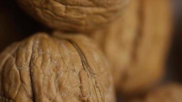 Cinematic, rotating shot of walnuts in their shells on a white surface - WALNUTS 065 video