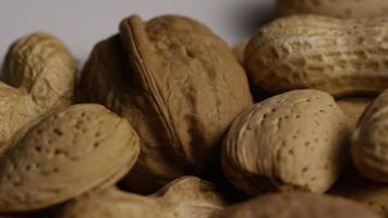 Cinematic, rotating shot of a variety of nuts on a white surface - NUTS MIXED 028 video