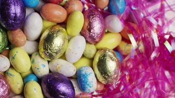 Tourné en rotation de bonbons de Pâques colorés sur un lit d'herbe de Pâques - Pâques 159 video