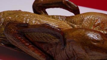 A full smoked duck on a white surface with a red background - SMOKED DUCK 012 video