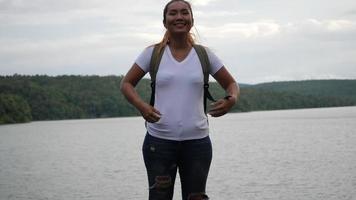 ultrarapid av kvinna med armar upp på sjön och berget