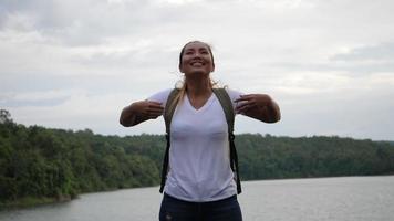 Slow motion of woman with arms raised on the lake and mountain video