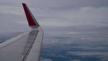 vleugel van een vliegtuig vliegt boven de wolken vanuit venster vliegtuig uitzicht video