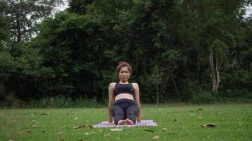 hermosa mujer está haciendo yoga en el parque
