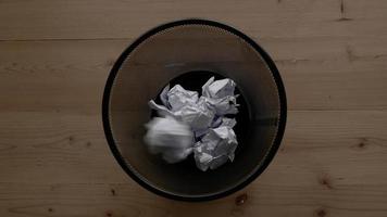 Throw crumpled paper into trash with black background video