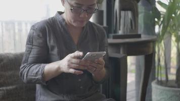 vrouw met behulp van slimme telefoon in restaurant. video