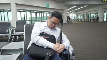 Tired businessman sleeping while waiting for the plane at airport. video