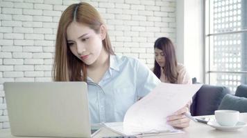 Aziatische zakenvrouwen in slimme vrijetijdskleding komen op laptop.